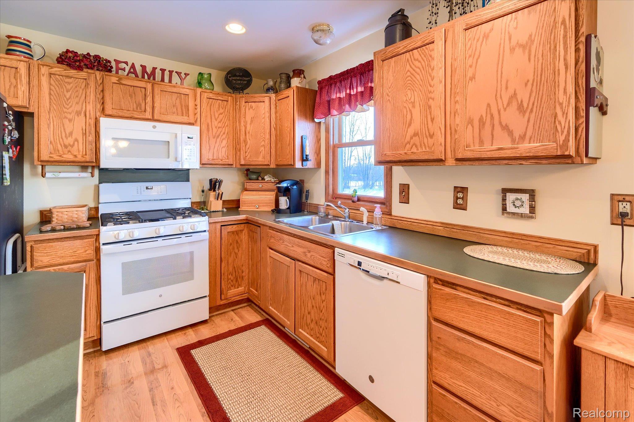 6941 North Lake Pleasant Road North Branch, MI 48461 - Photo 14 of 51 Kitchen featuring white appliances and light wood-style flooring