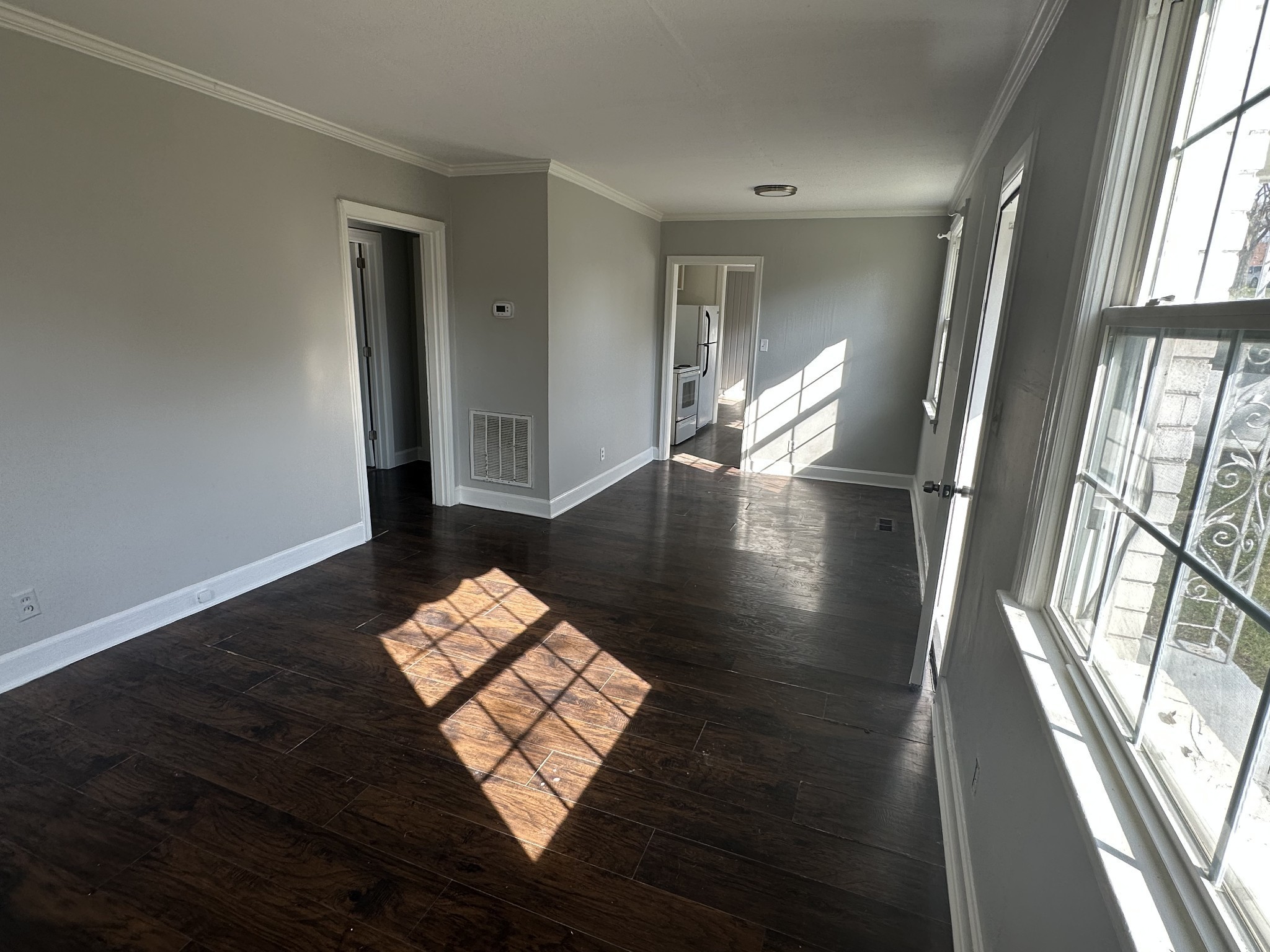 a view of wooden floor in an empty room with a window