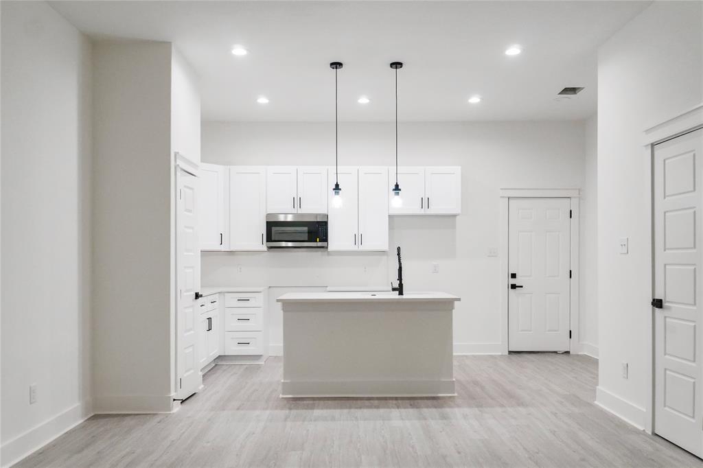 2642 Sutton Street Dallas, TX 75210 - Photo 4 of 12 a large kitchen with stainless steel appliances a large counter top and a wooden floors