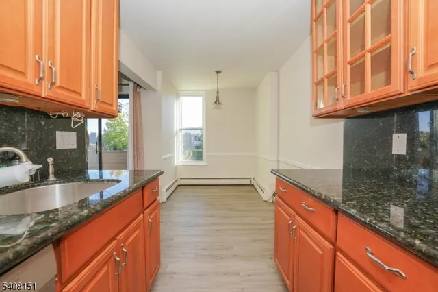 a view of a kitchen with granite countertop a sink and a window