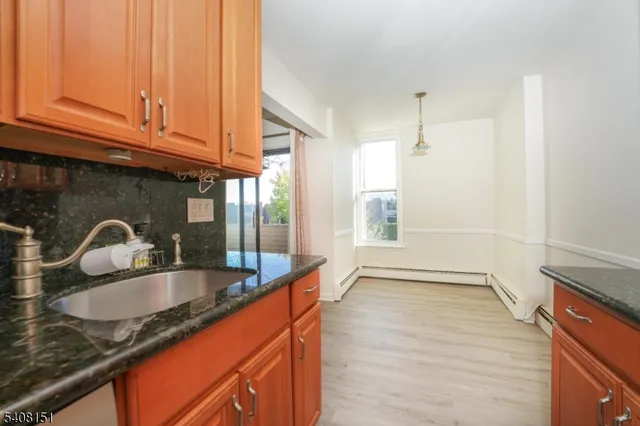a kitchen with granite countertop a sink and cabinets