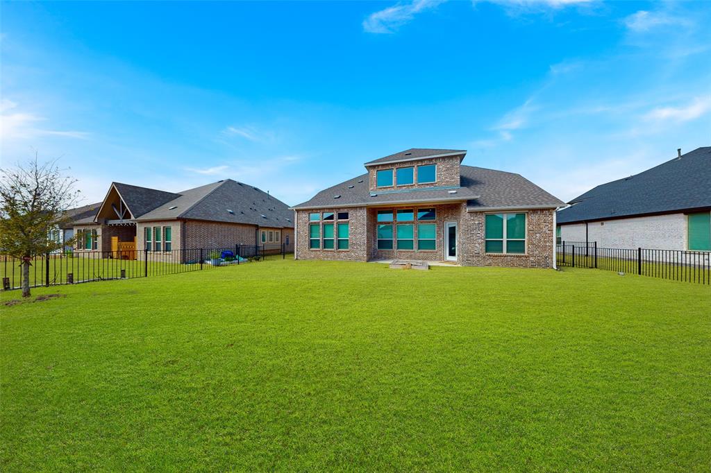 4028 Yellow Jasmine Lane Heath, TX 75126 - Photo 32 of 38 Rear view of property with a fenced backyard, a lawn, and brick siding