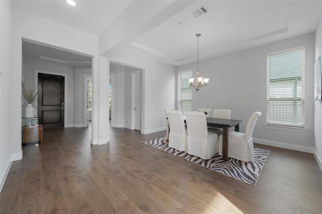 4028 Yellow Jasmine Lane Heath, TX 75126 - Photo 5 of 38 Dining space with a notable chandelier, dark wood-type flooring, visible vents, and baseboards