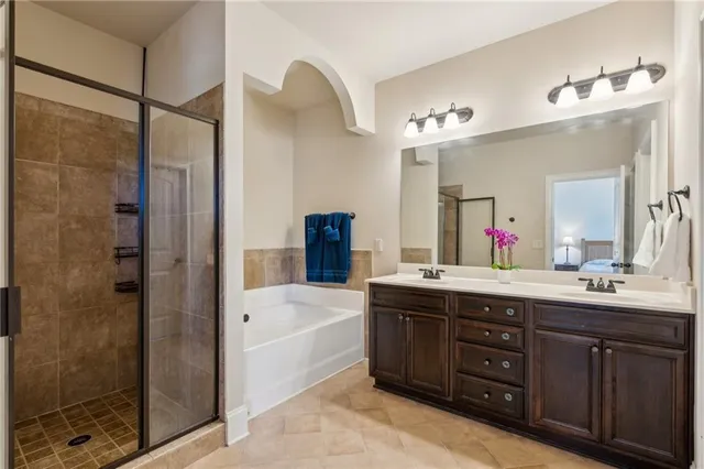 a bathroom with a tub sink shower and mirror
