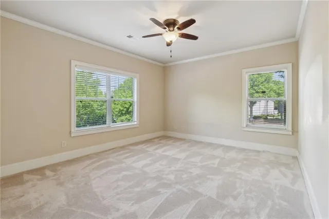 an empty room with windows and a ceiling fan