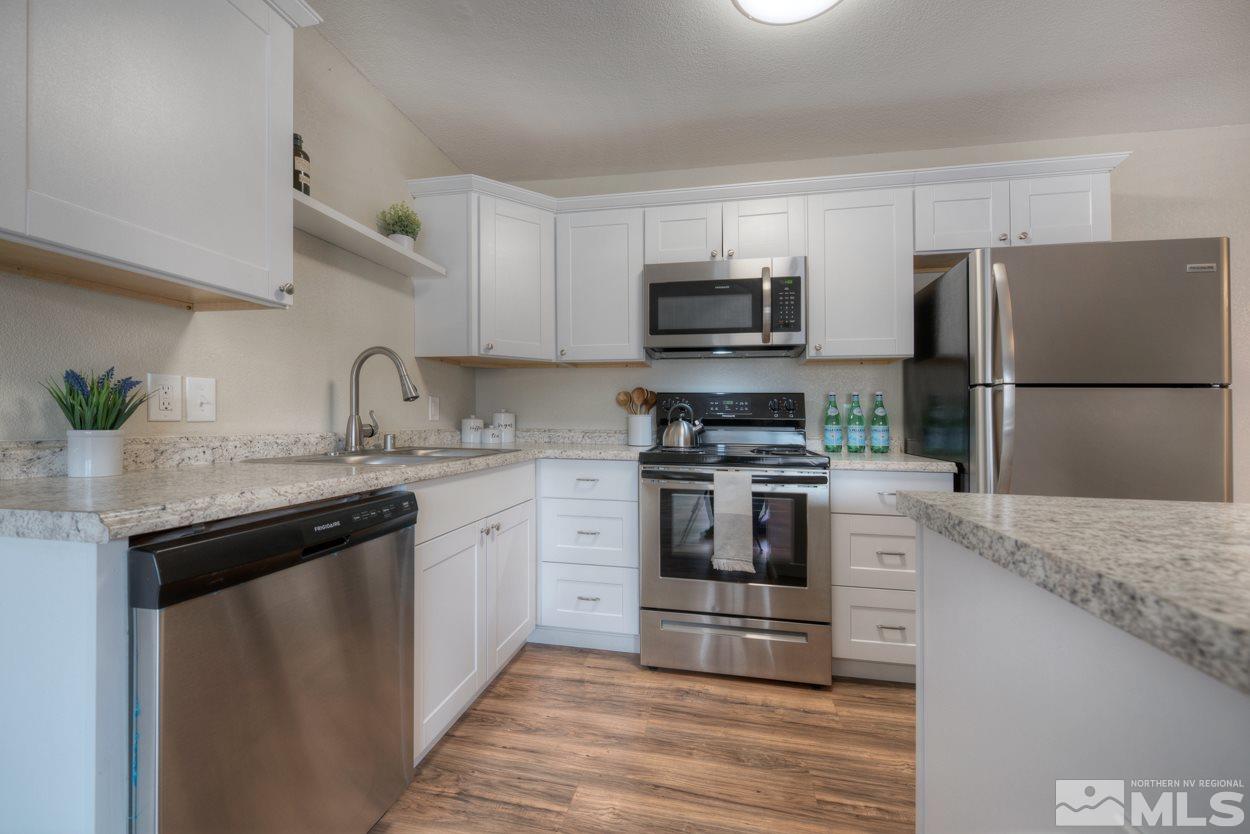 2150 Sutro Street, Unit A Reno, NV 89512 - Photo 2 of 25 a kitchen with kitchen island granite countertop a sink stainless steel appliances and white cabinets