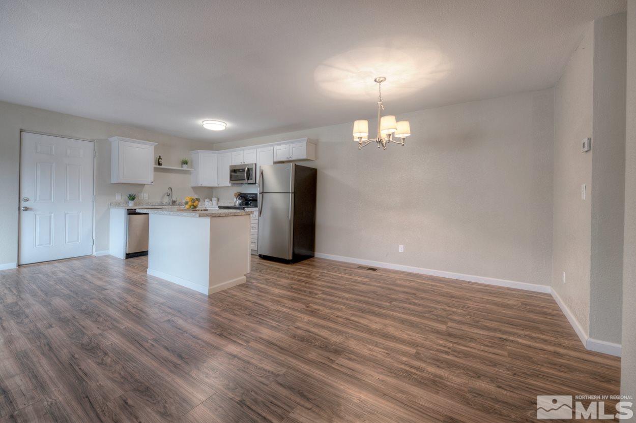 2150 Sutro Street, Unit A Reno, NV 89512 - Photo 4 of 25 a view of a refrigerator in kitchen and wooden floor