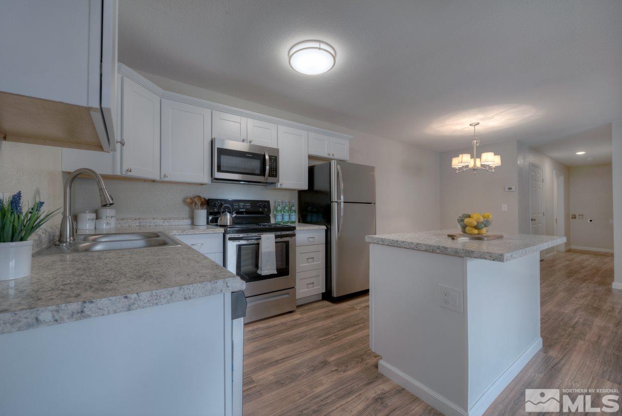 2150 Sutro Street, Unit A Reno, NV 89512 - Photo 5 of 25 a kitchen with kitchen island a sink stainless steel appliances and cabinets