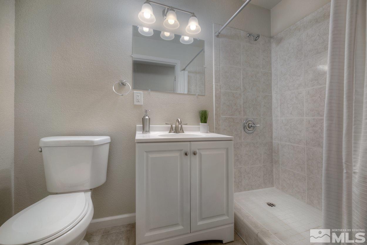2150 Sutro Street, Unit A Reno, NV 89512 - Photo 10 of 25 a bathroom with a sink a toilet a shower and a mirror