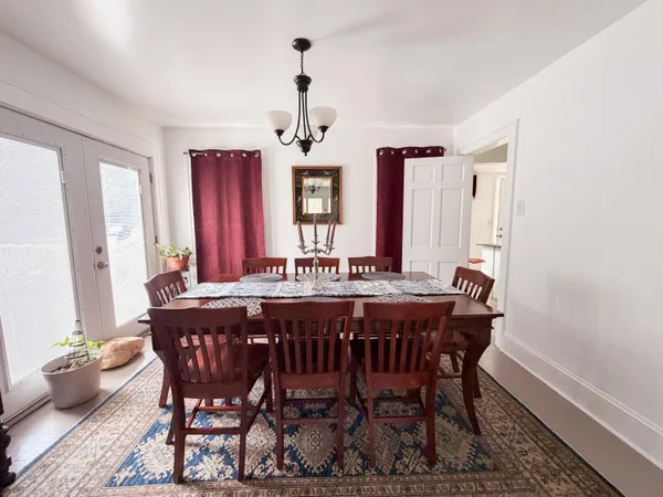 a view of a a dining room with furniture window and wooden floor