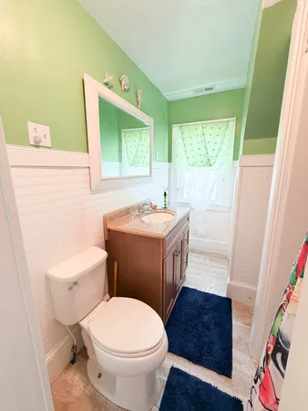 a bathroom with a sink a toilet and a mirror