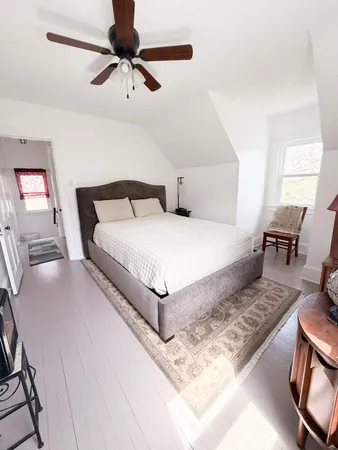 a bedroom with a bed chandelier and a window