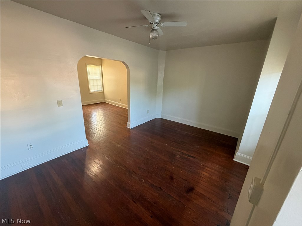 15416 Waterloo Road Cleveland, OH 44110 - Photo 3 of 18 Hardwood flooring and light-toned walls in a room featuring a ceiling fan and a cased opening to an additional room