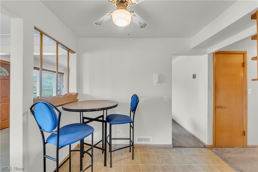 3023 Norris Avenue Cleveland, OH 44134 - Photo 17 of 41 Kitchenette area featuring tiled flooring, a pass-through window with wood trim, and a ceiling fan with integrated lighting
