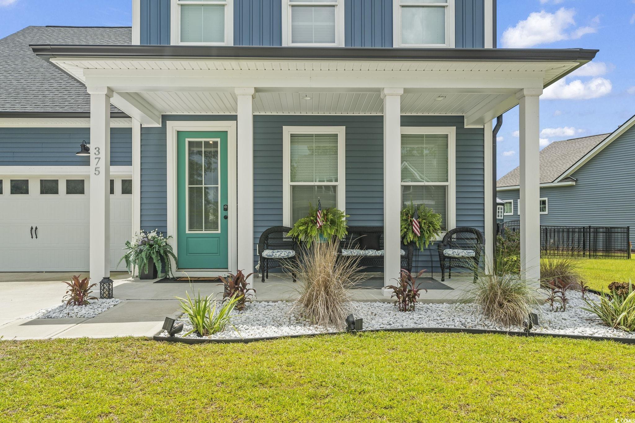 375 Bumble Circle Murrells Inlet, SC 29576 - Photo 29 of 40 Exterior space with a porch, a garage, and a lawn