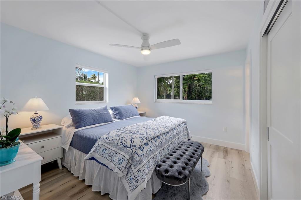 780 10th Avenue South, Unit 2 Naples, FL 34102 - Photo 2 of 23 a bedroom with a bed and a chandelier