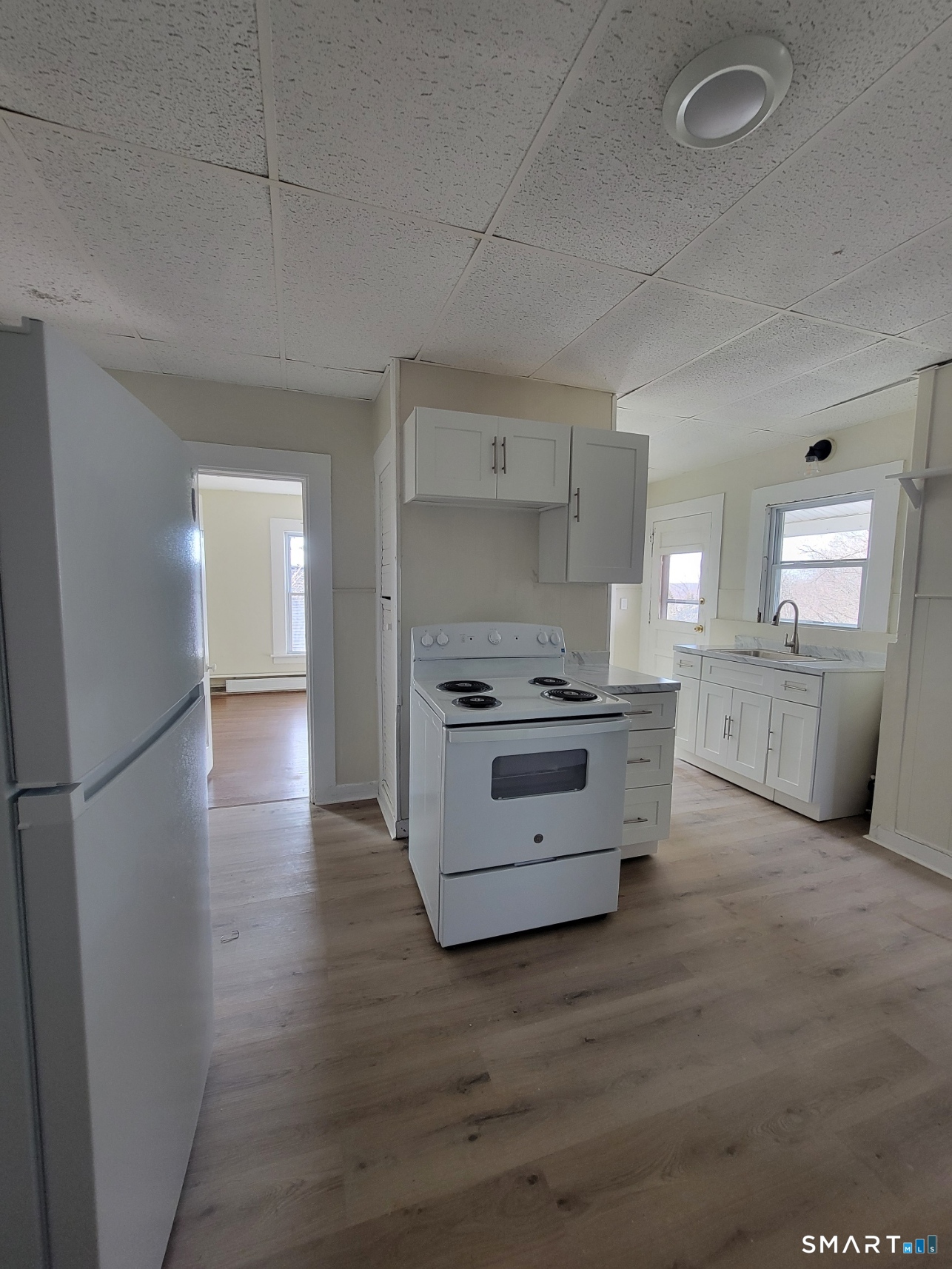 260 Summit Street, Unit 2B Windham, CT 06226 - Photo 1 of 1 a kitchen with stainless steel appliances kitchen island wooden floors and white cabinets