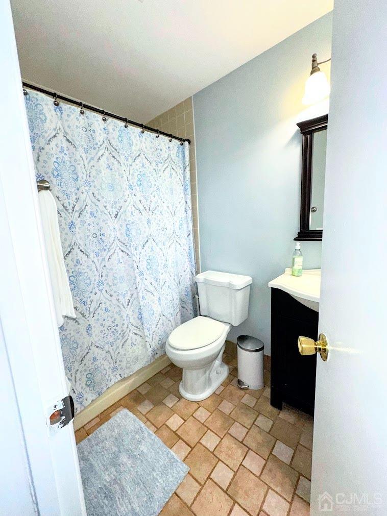 60 County Road, Unit 33F Cliffwood, NJ 07721 - Photo 13 of 13 a bathroom with a toilet and a shower curtain