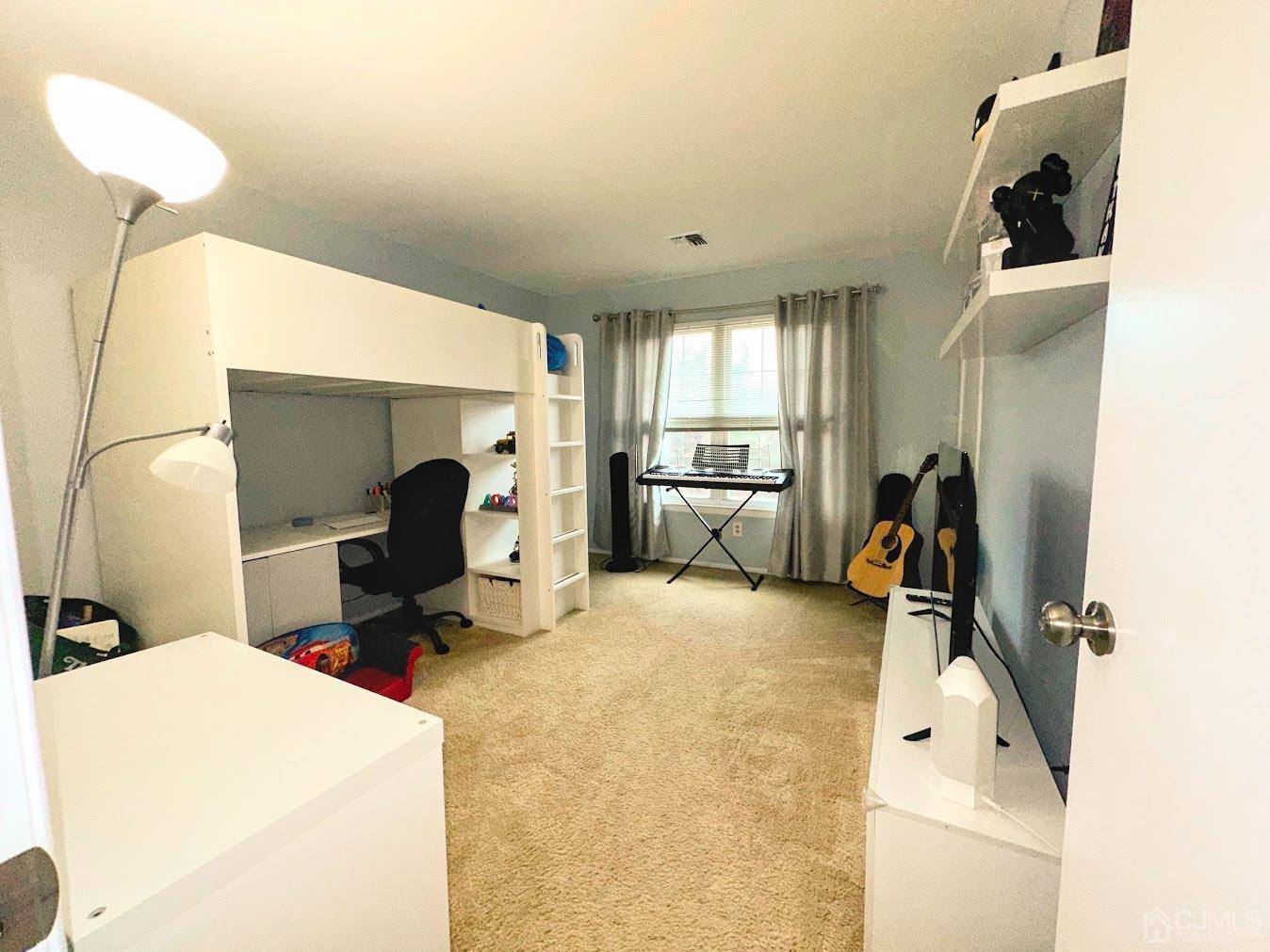 60 County Road, Unit 33F Cliffwood, NJ 07721 - Photo 10 of 13 a room with a bed a gym equipment and a view of living room