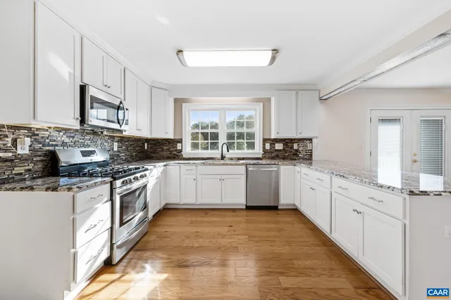 a bathroom with a granite countertop double vanity sink and mirror