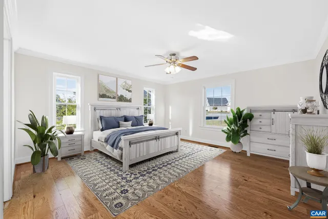 an empty room with wooden floor ceiling fan and windows