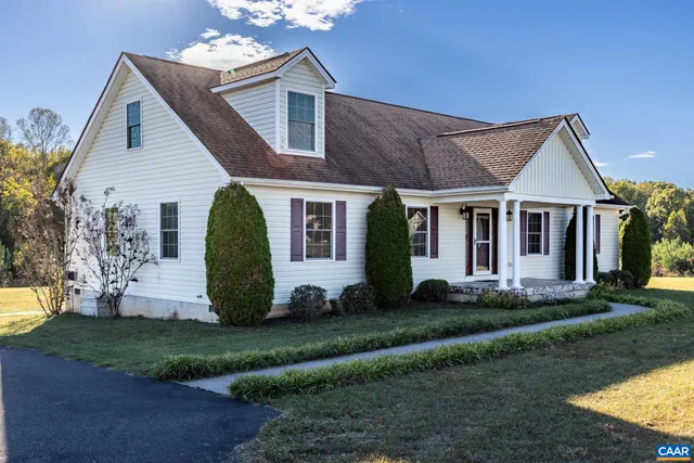 a view of a white house with a yard and plants