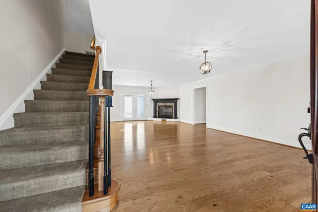 a view of an empty room with stairs and a ceiling fan