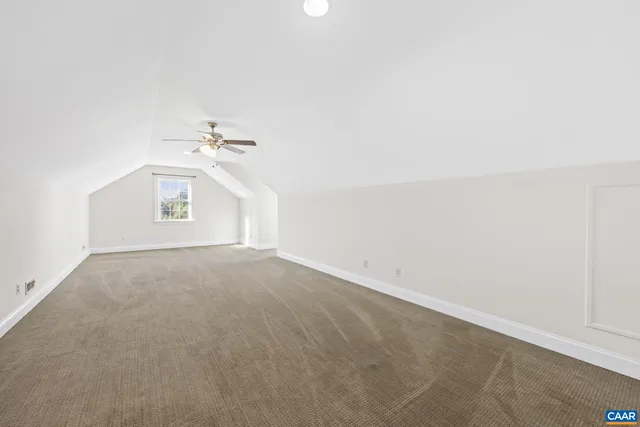 an empty room with closet and a ceiling fan