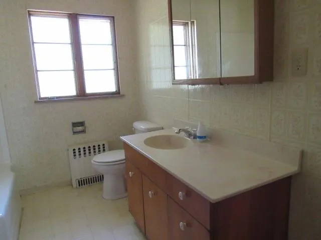 a bathroom with a sink a toilet and a window