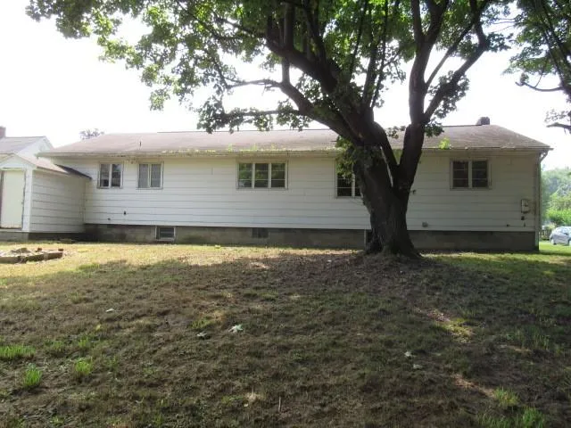 a view of a house with a large tree