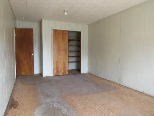 an empty room with closet and mirror