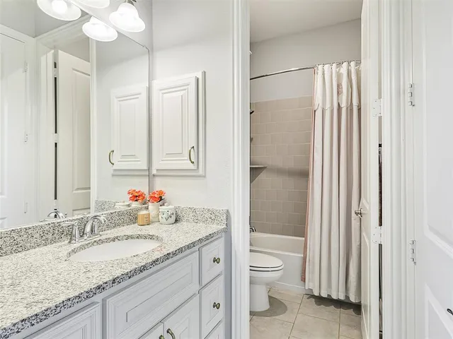 a bathroom with a granite countertop sink mirror vanity and toilet