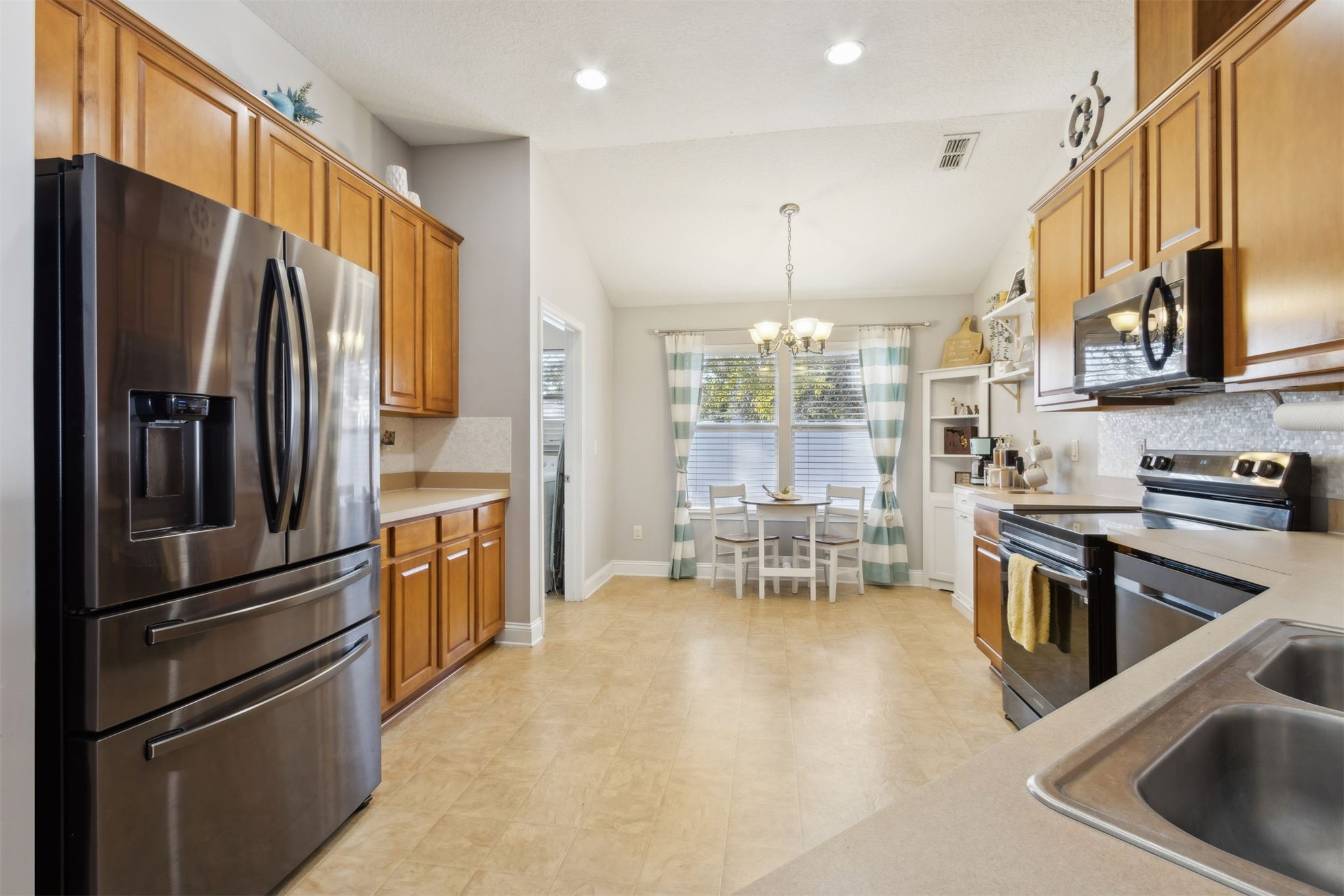 86027 Maple Leaf Place Yulee, FL 32097 - Photo 14 of 38 a kitchen with stainless steel appliances granite countertop a refrigerator stove and sink