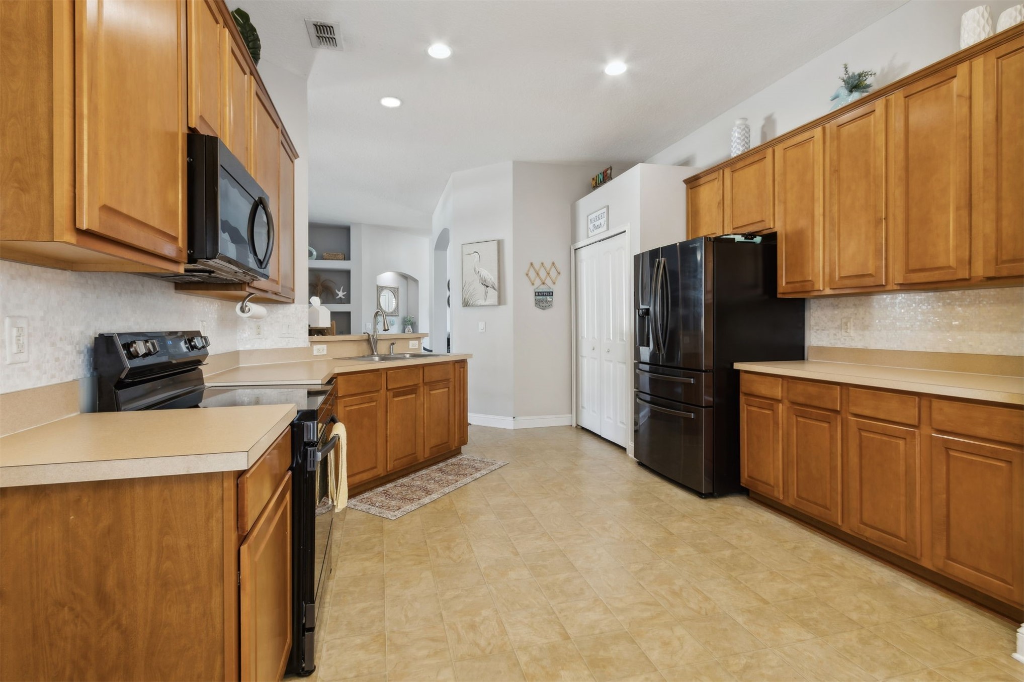 86027 Maple Leaf Place Yulee, FL 32097 - Photo 16 of 38 a kitchen with stainless steel appliances granite countertop a refrigerator a stove top oven a sink and dishwasher