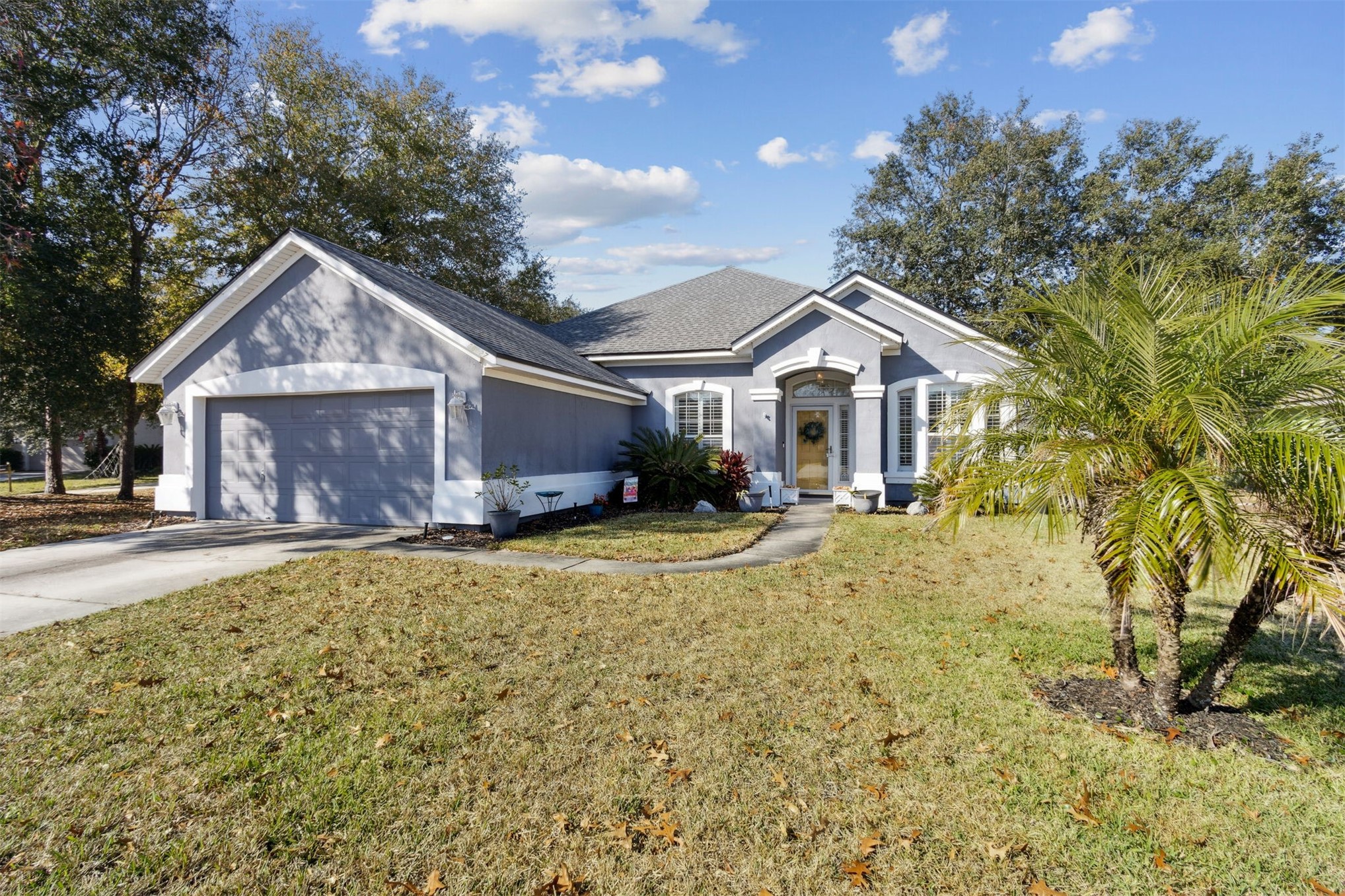 86027 Maple Leaf Place Yulee, FL 32097 - Photo 2 of 38 a view of a house with a yard and large tree