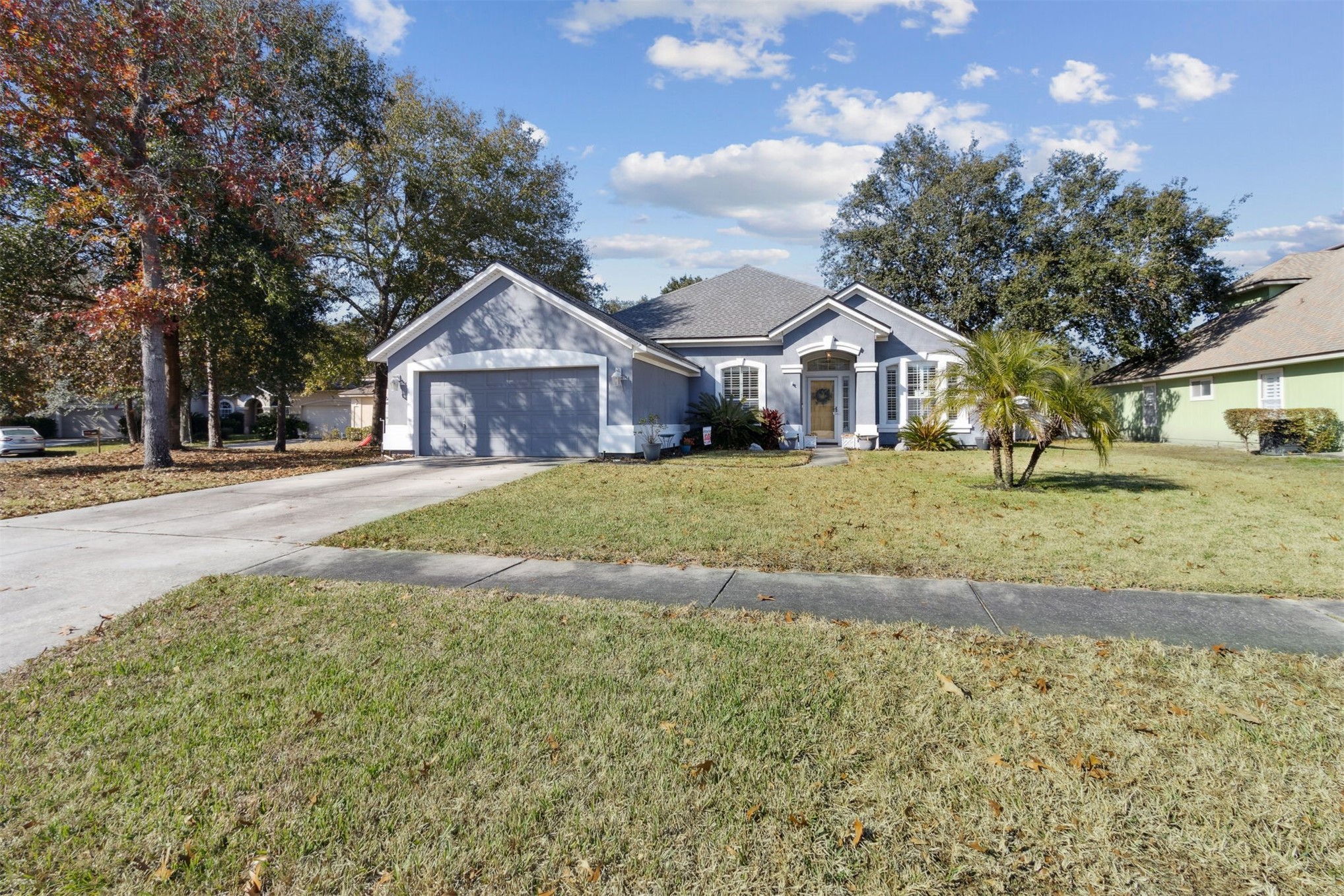 86027 Maple Leaf Place Yulee, FL 32097 - Photo 3 of 38 a front view of a house with a yard and trees