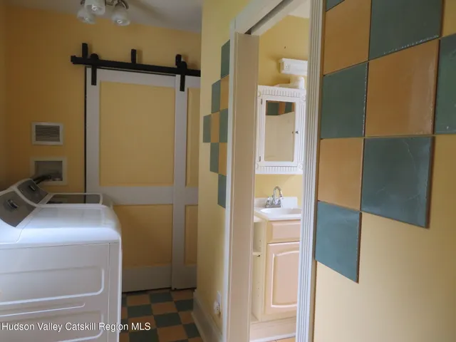 a view of a hallway with wooden floor and a bathroom