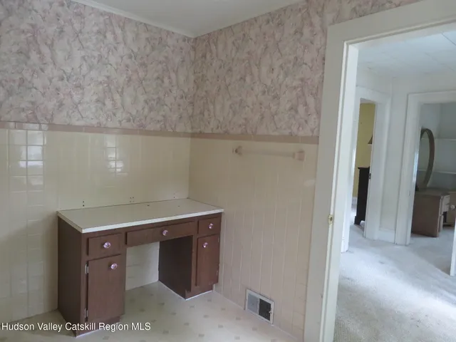 a view of a hallway with toilet and a livingroom view