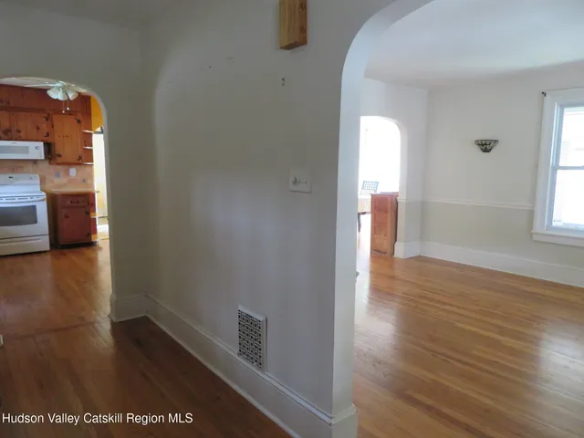 a view of a hallway with wooden floor and closet