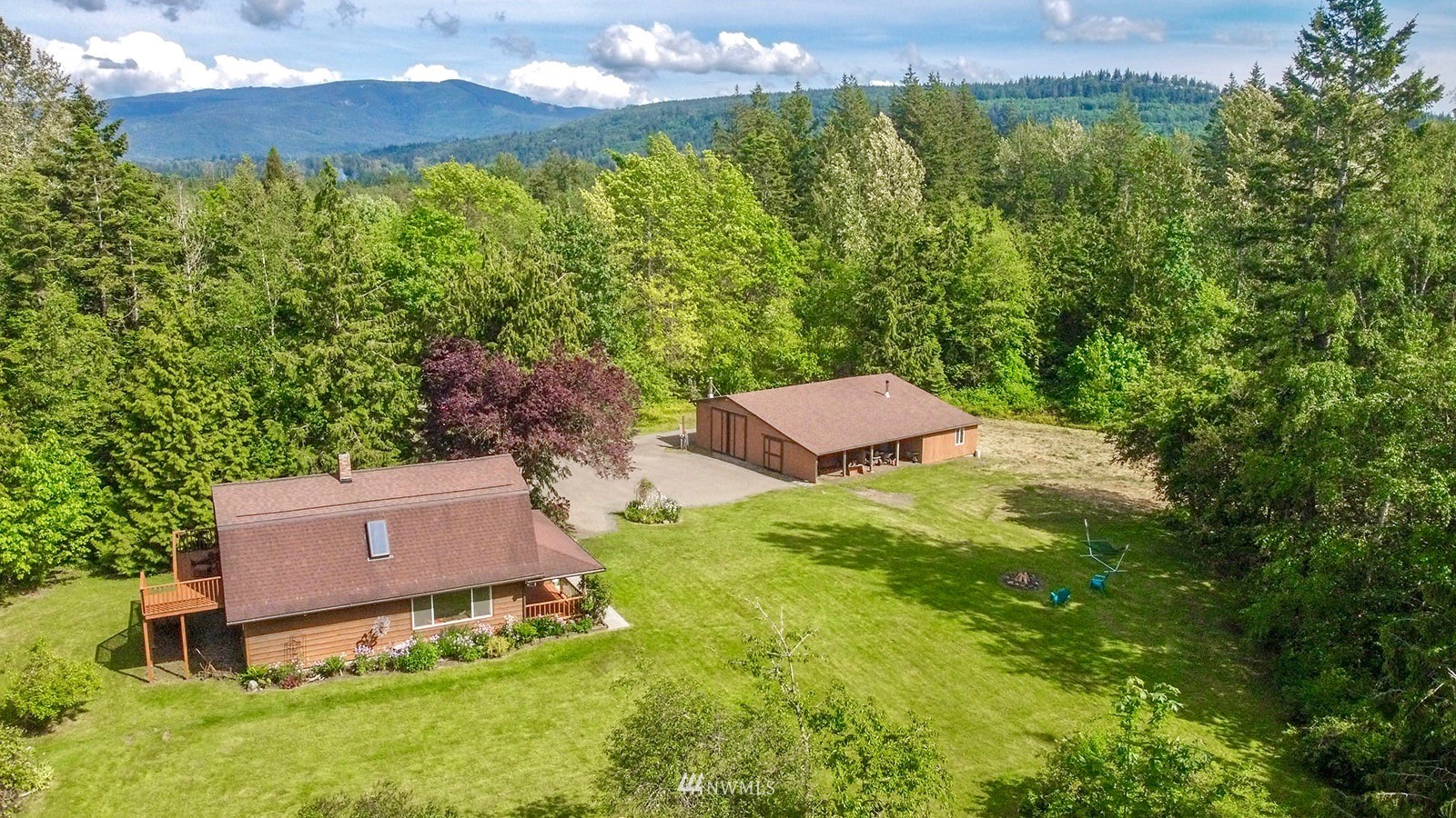 an aerial view of residential house with outdoor space and trees all around