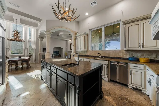 a kitchen with stainless steel appliances granite countertop a sink stove and cabinets