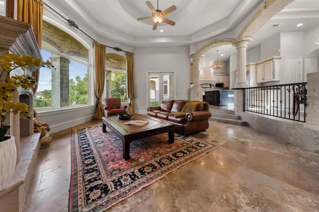 a living room with furniture a table and a large window