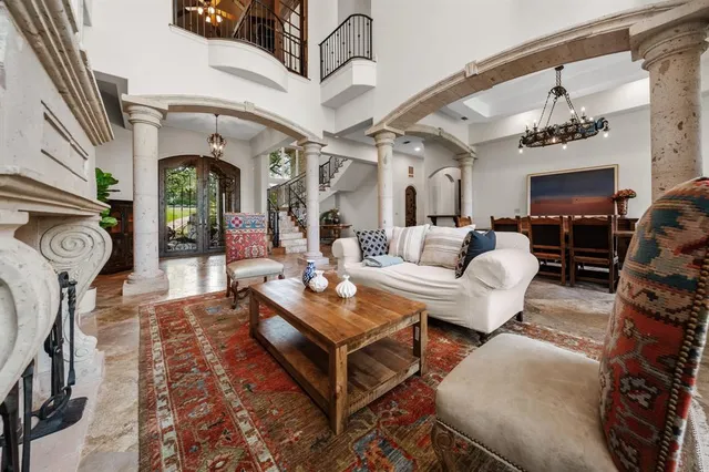 a living room with furniture a fireplace and a chandelier