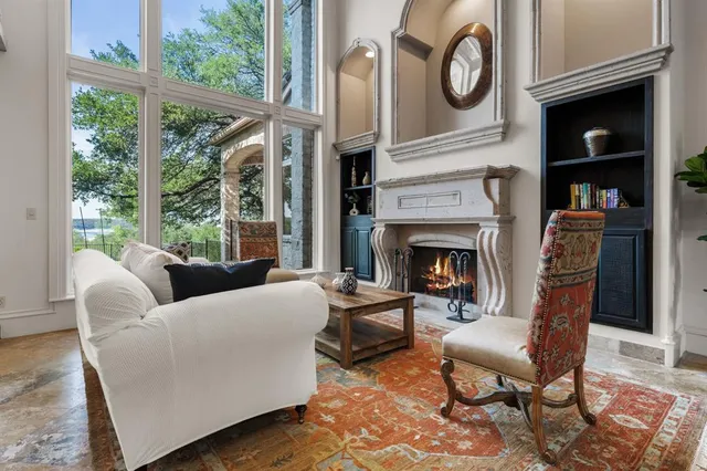 a living room with furniture a fireplace and a large window