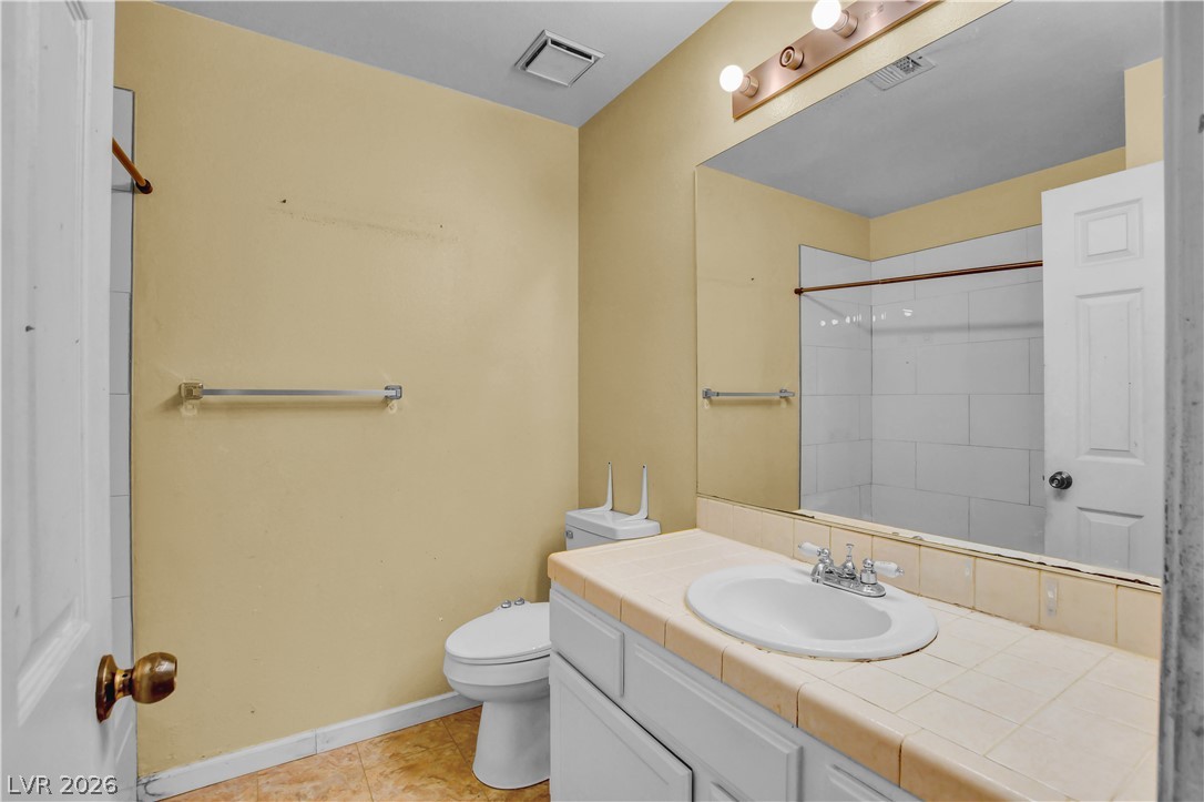 6440 Hartwood Road Las Vegas, NV 89108 - Photo 36 of 59 A well-lit bathroom features a vanity with a white sink and a large mirror.