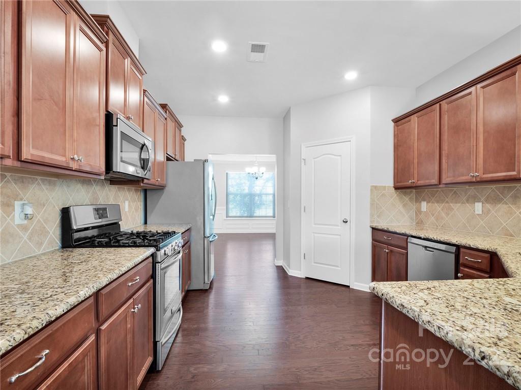 10502 Ebbets Road Charlotte, NC 28273 - Photo 12 of 48 a kitchen with stainless steel appliances granite countertop wooden cabinets a stove a sink and dishwasher