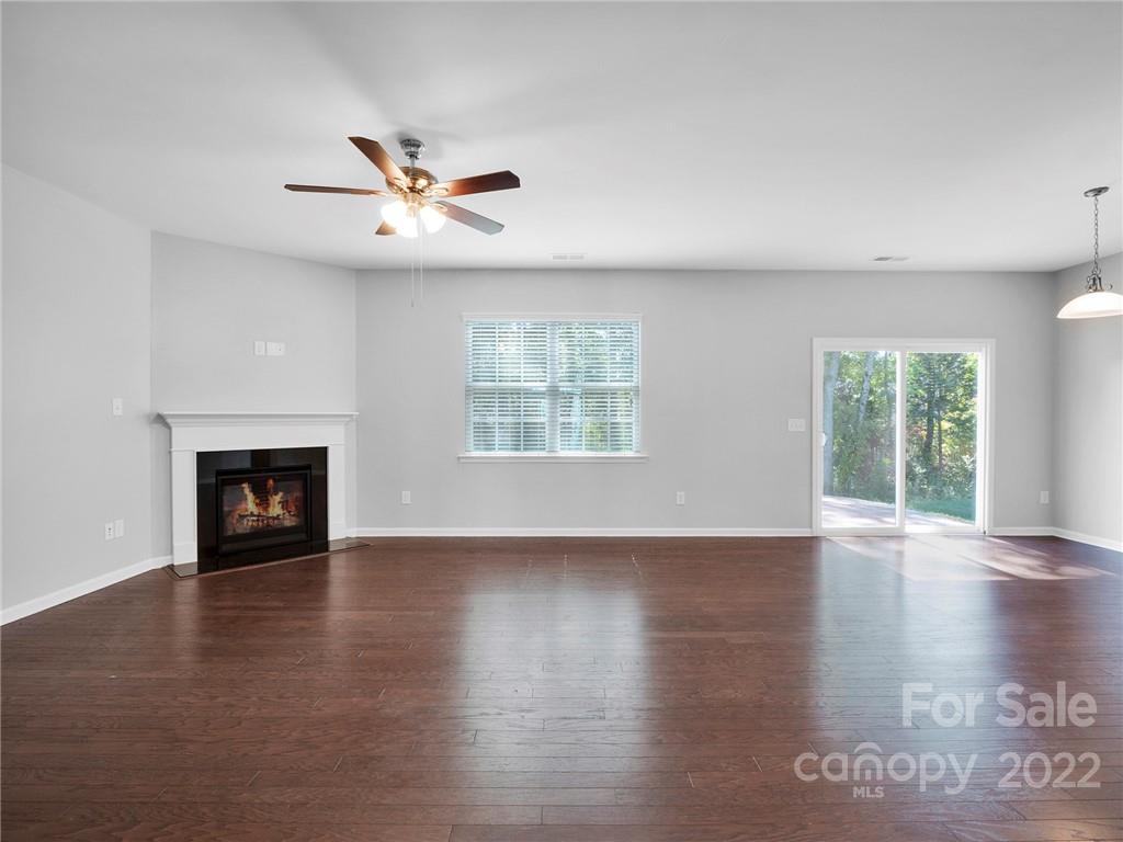 10502 Ebbets Road Charlotte, NC 28273 - Photo 20 of 48 an empty room with wooden floor fireplace and windows