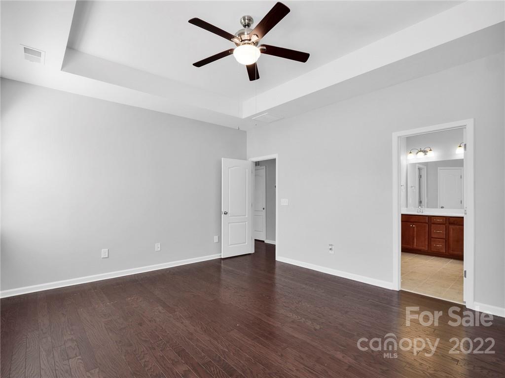 10502 Ebbets Road Charlotte, NC 28273 - Photo 25 of 48 an empty room with wooden floor and a ceiling fan