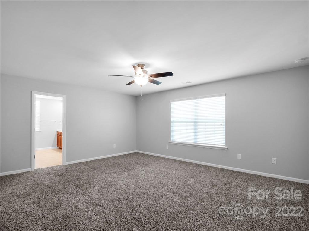 10502 Ebbets Road Charlotte, NC 28273 - Photo 26 of 48 an empty room with windows and chandelier fan