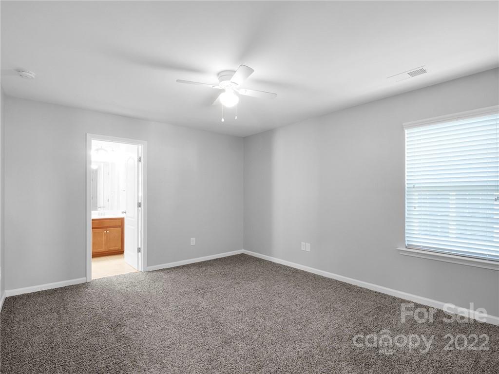 10502 Ebbets Road Charlotte, NC 28273 - Photo 31 of 48 an empty room with chandelier fan and windows